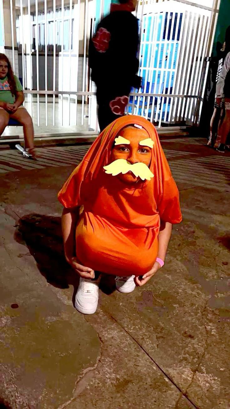 a person in an orange outfit with a moustache on their face