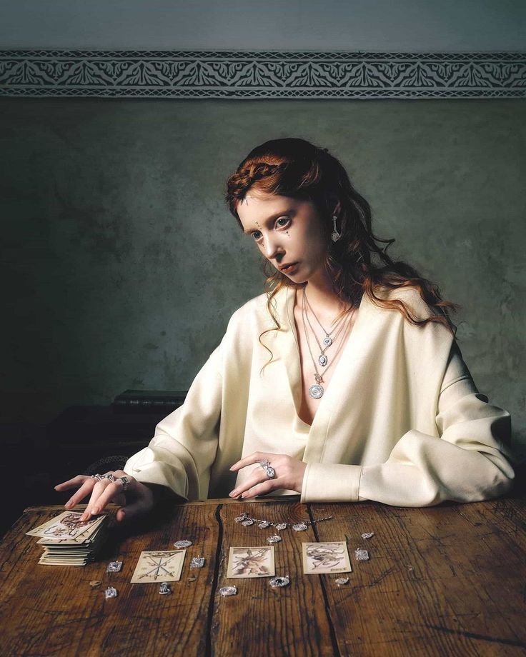 a woman sitting at a table with cards in front of her