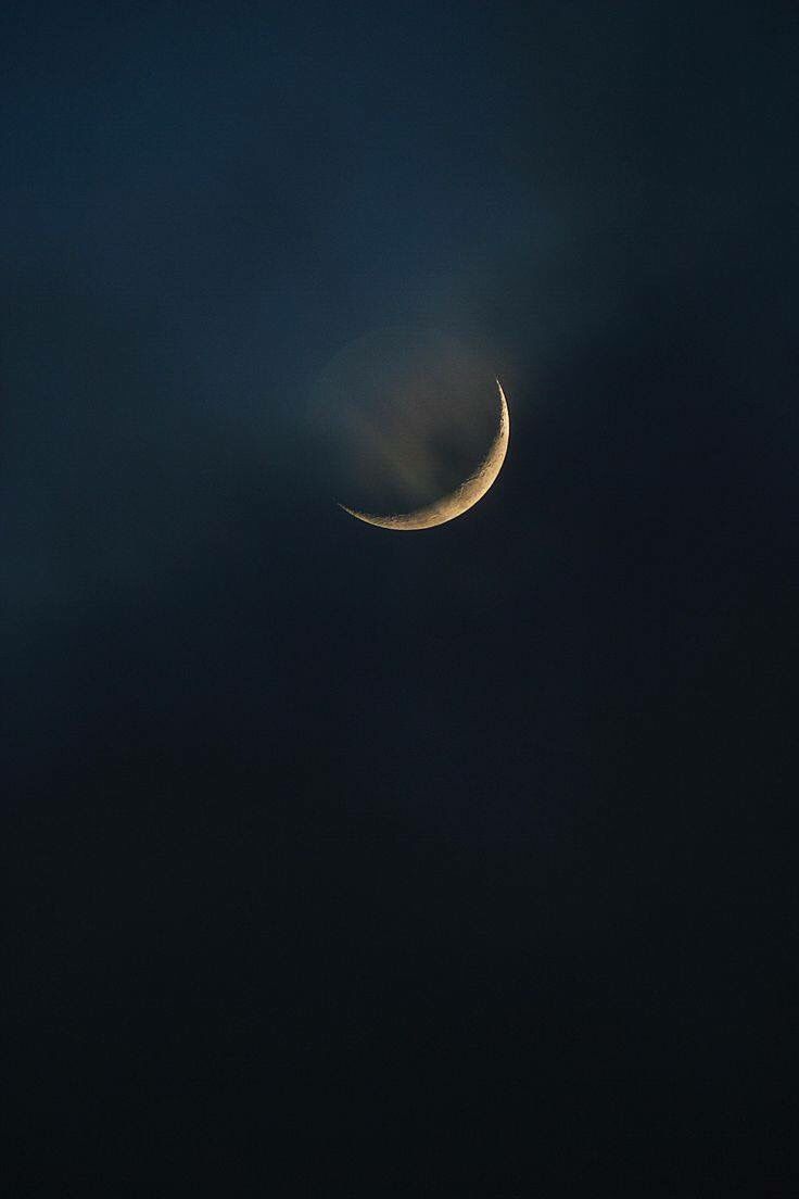 the moon is seen in the dark sky with no clouds on its side, as it appears to be partially obscured by fog