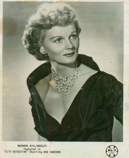 an old black and white photo of a woman in a dress with pearls on her necklace