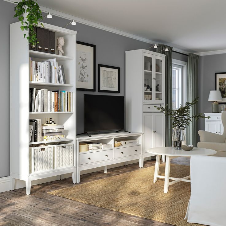 a living room filled with furniture and a flat screen tv on top of a book shelf