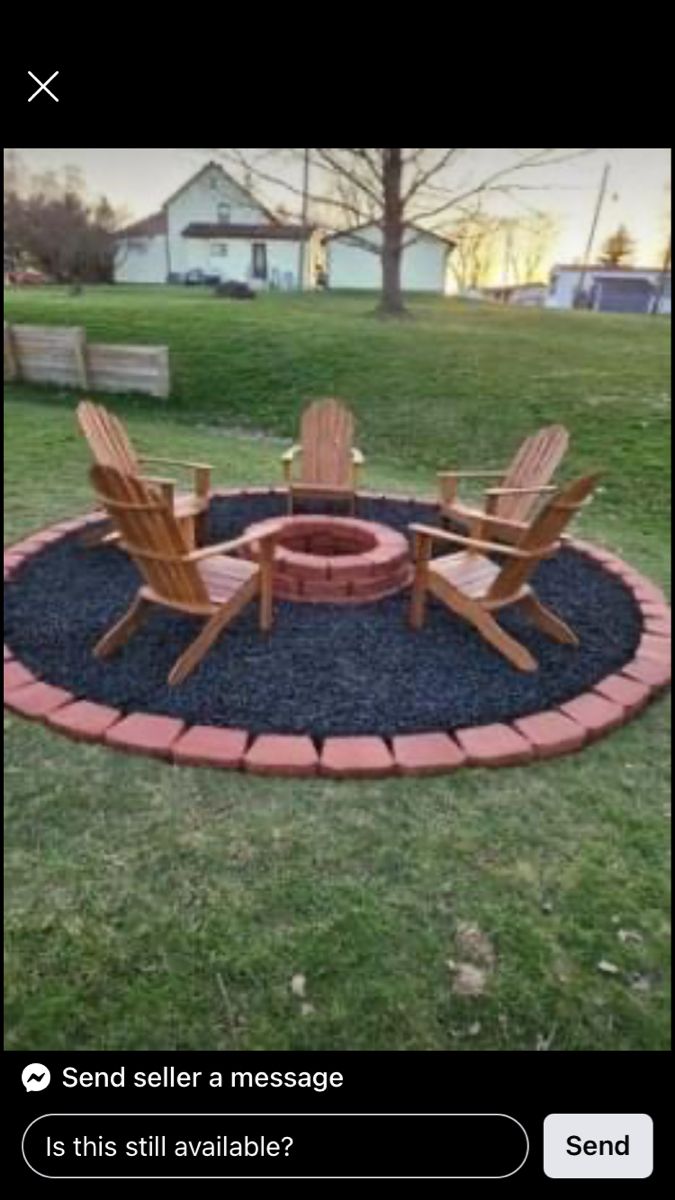 a fire pit with chairs around it in the middle of a yard and grass area