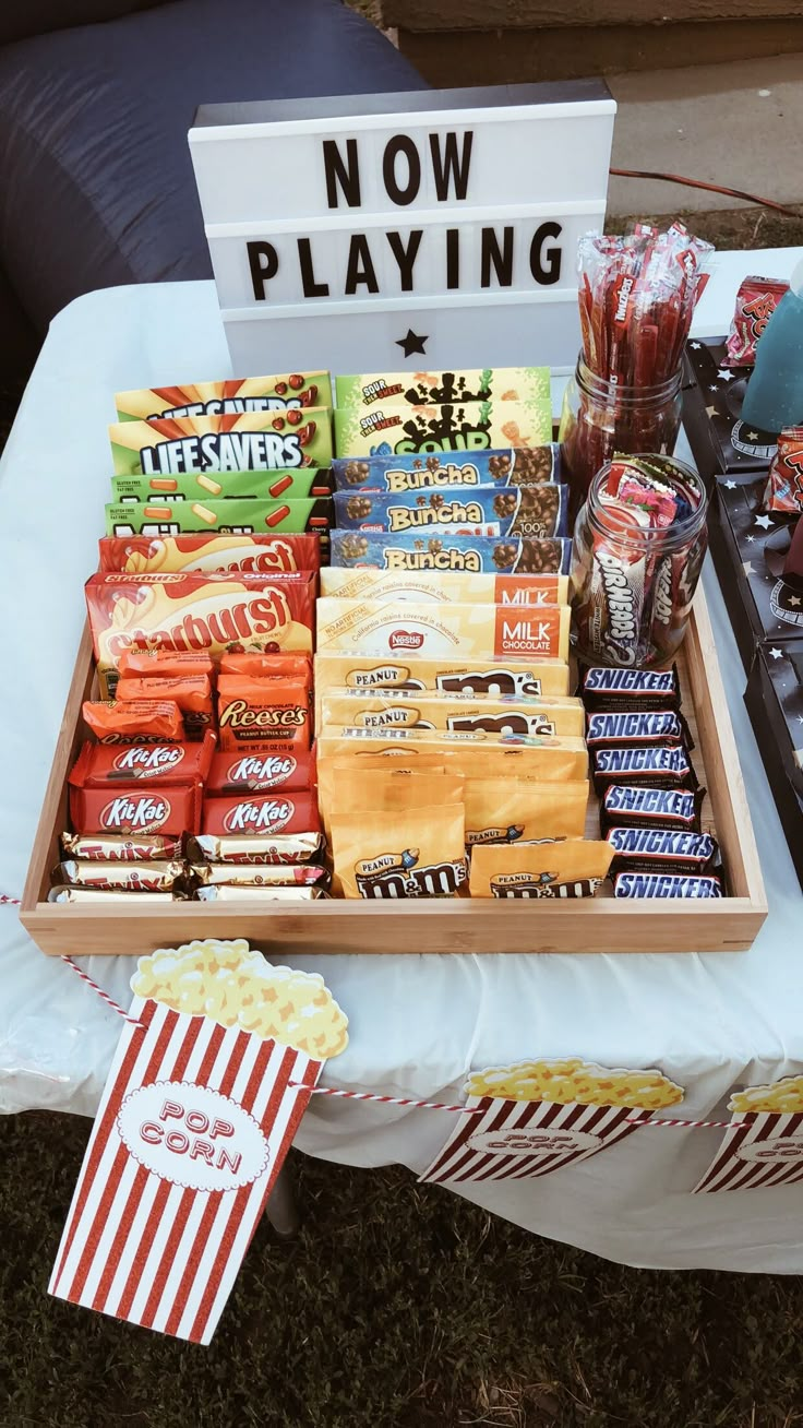 a tray filled with snacks sitting on top of a table next to a sign that says now playing