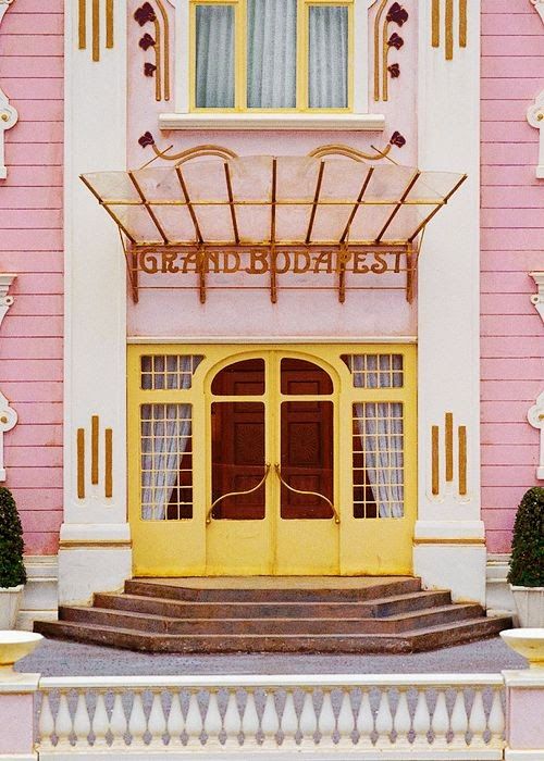 a pink and white building with yellow doors