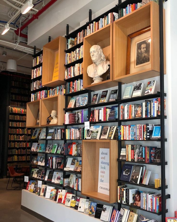 a bookshelf filled with lots of books next to a busturine