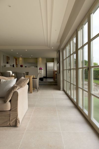 a living room filled with furniture and large windows