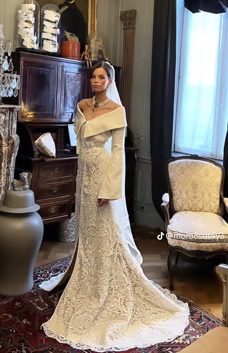 a woman in a wedding dress standing next to a dresser