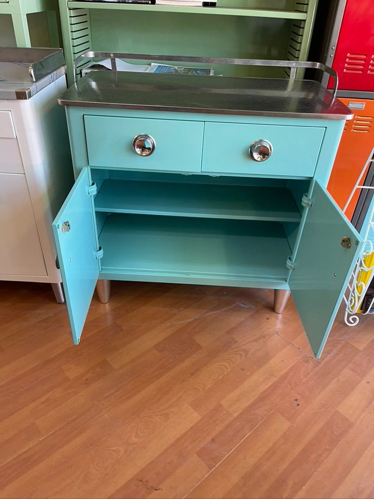 a blue cabinet sitting on top of a hard wood floor