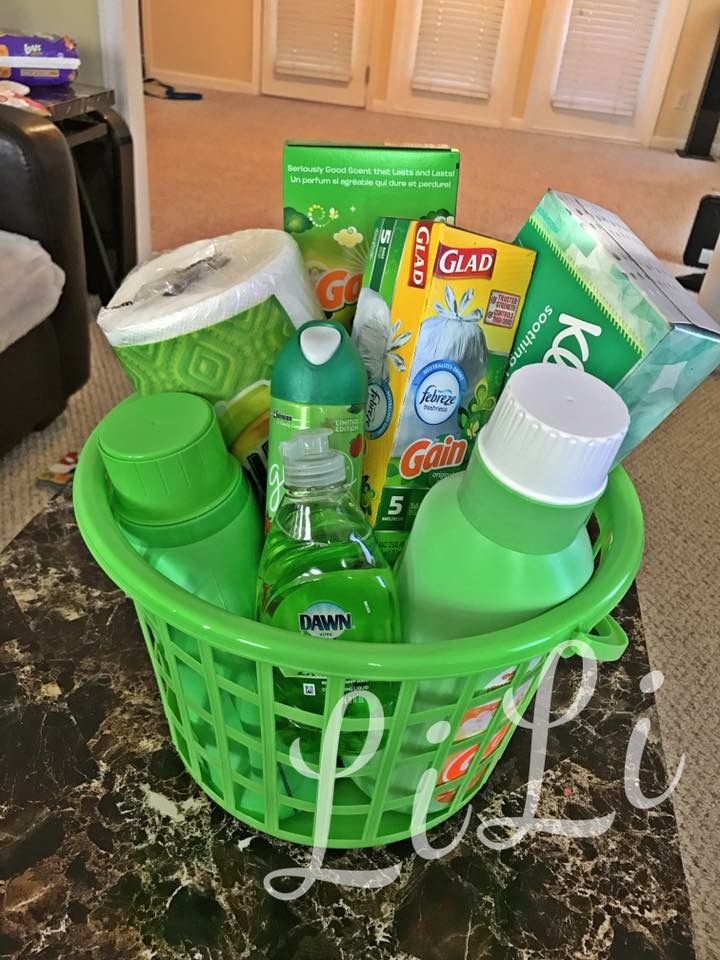 a green basket filled with baby items on top of a table