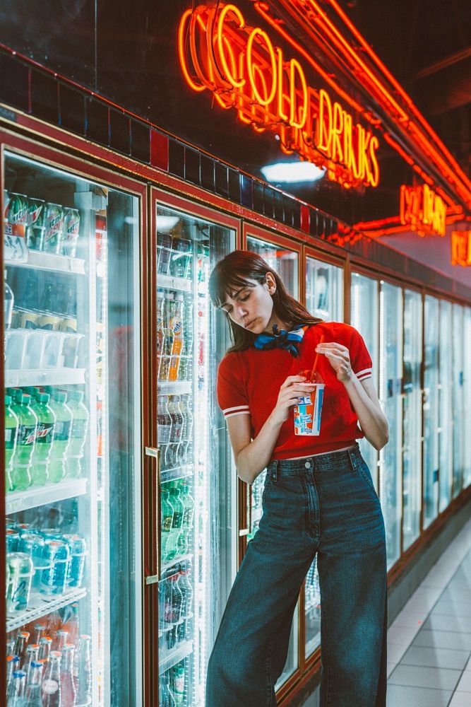 a woman standing in front of a refrigerator