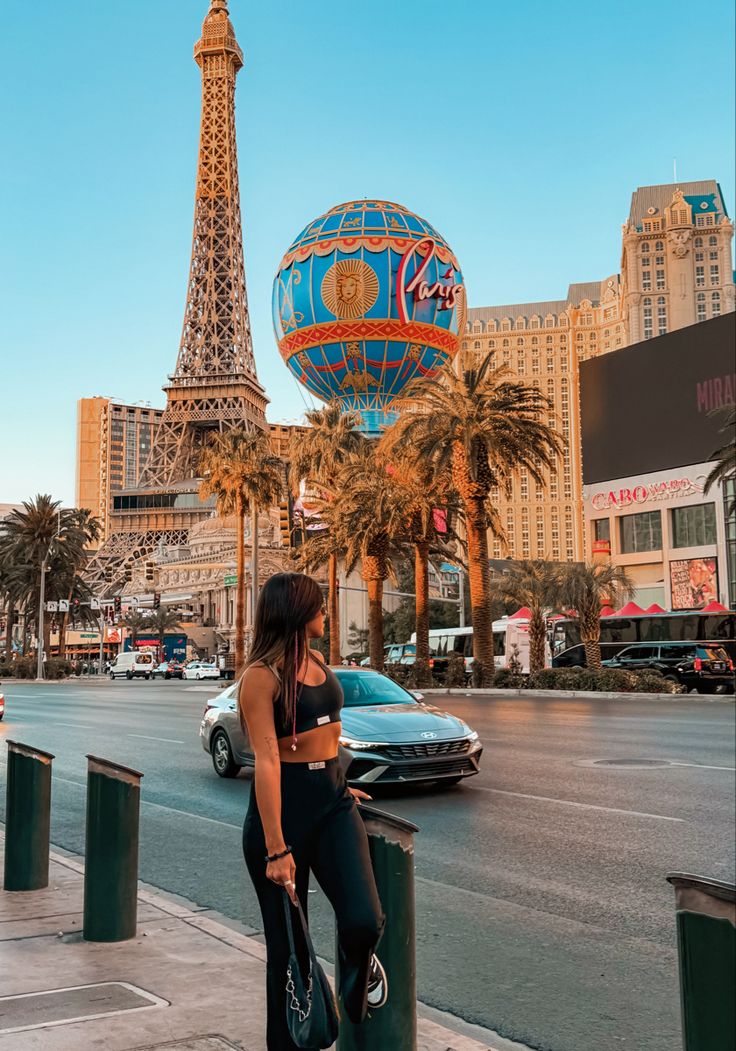 a woman standing in front of the eiffel tower with her hand on her hip