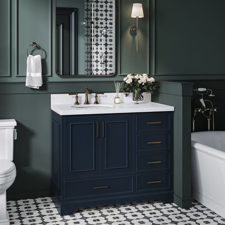 a white toilet sitting next to a bathroom sink under a mirror and a bath tub