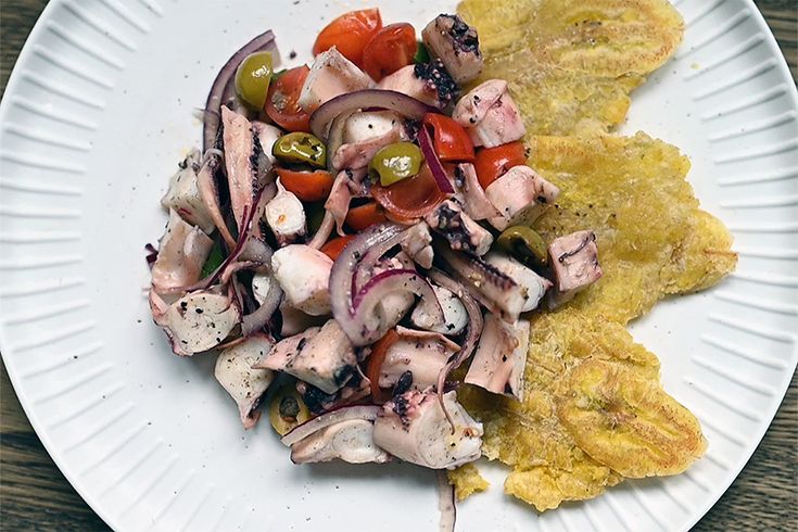 a white plate topped with meat and veggies next to an omelet