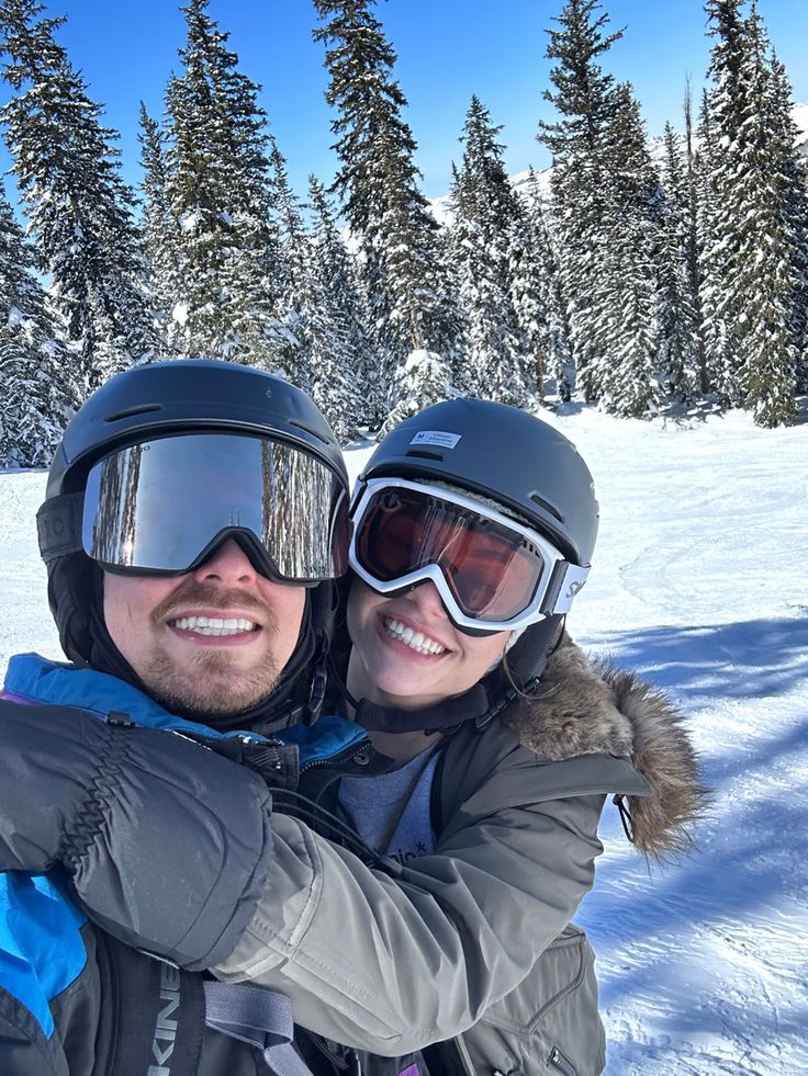 a man and woman wearing ski goggles in the snow