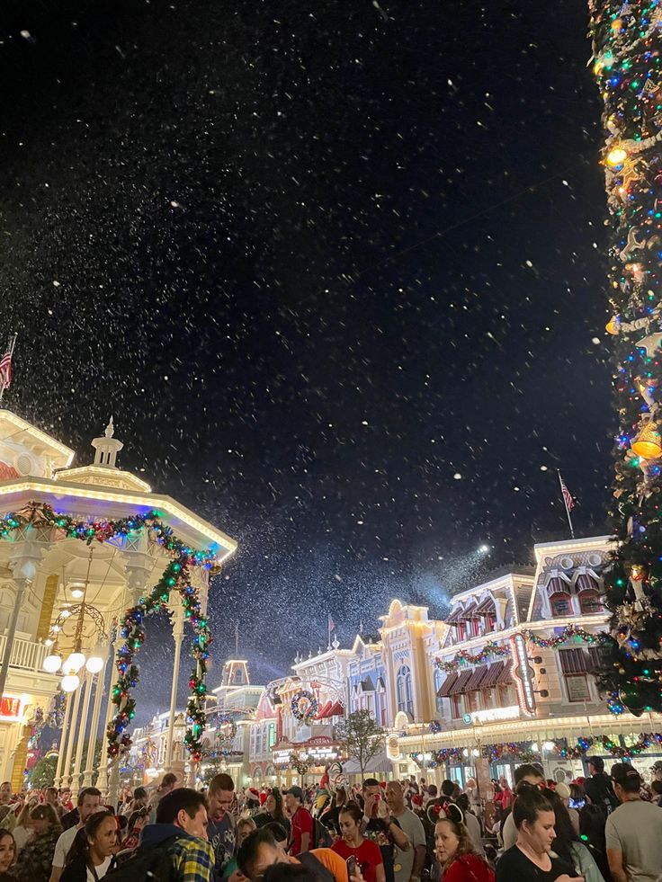 a crowd of people standing in front of a building with lights and decorations on it