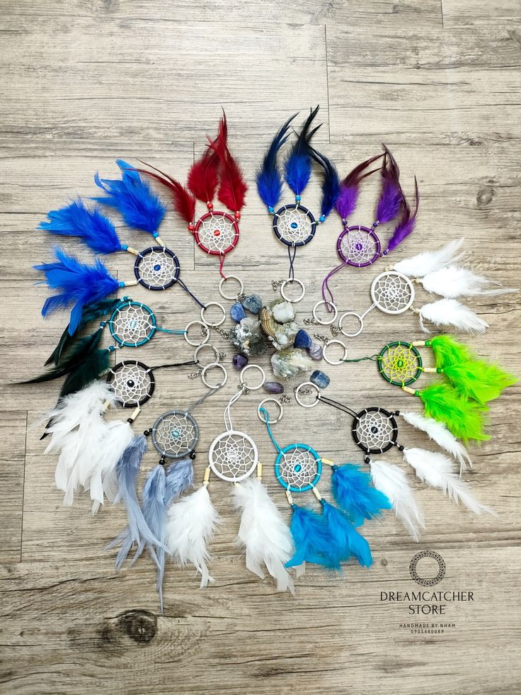 an assortment of dream catchers are arranged in a circle on a wooden floor with the words dream catcher written below them