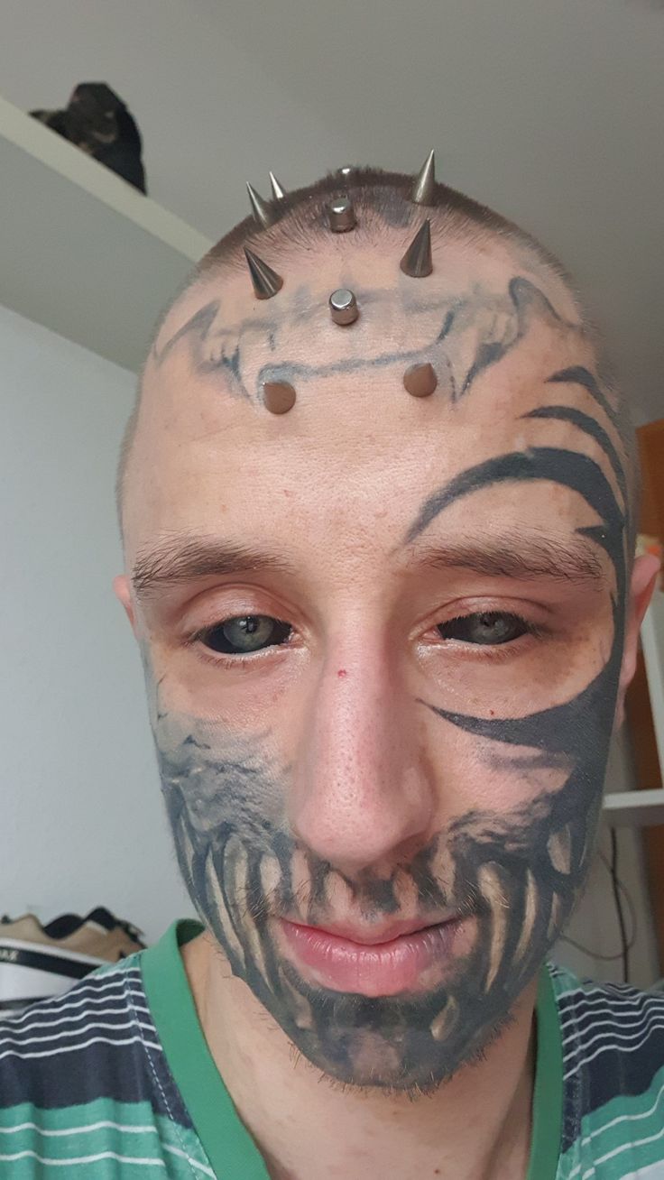 a man with tattoos and piercings on his face