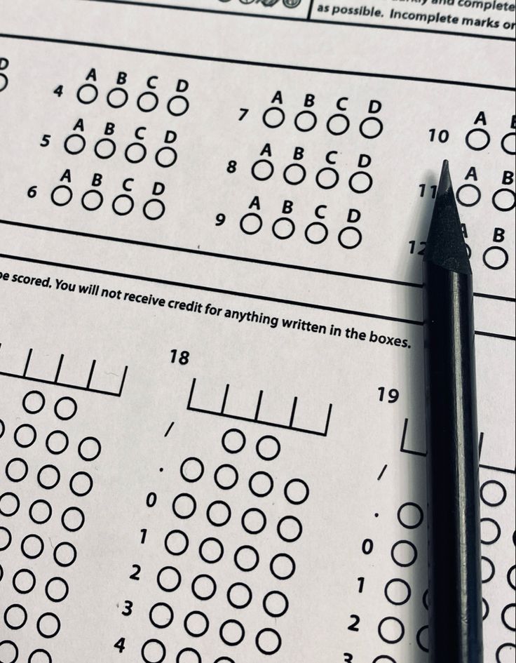 a pen sitting on top of a paper with numbers and lines in the form of letters