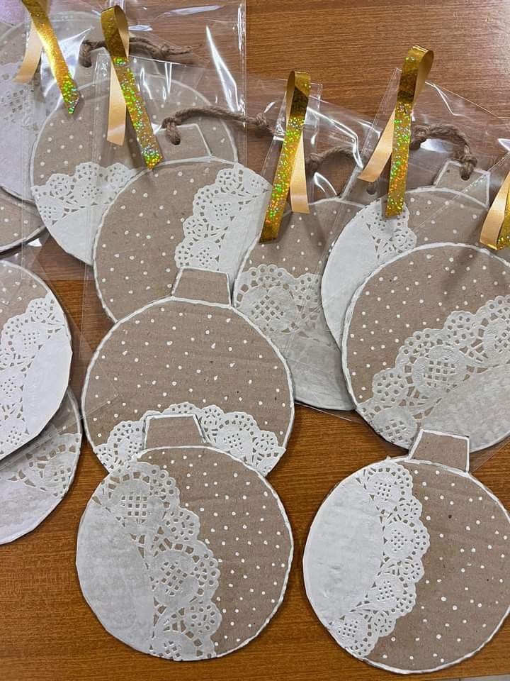 six lace doily christmas ornaments in plastic bags on a wooden table with gold ribbon