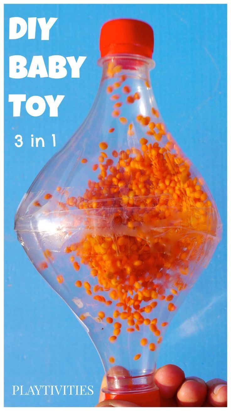 a hand holding a bottle filled with tiny orange seeds and text that reads diy baby toy 3 in 1