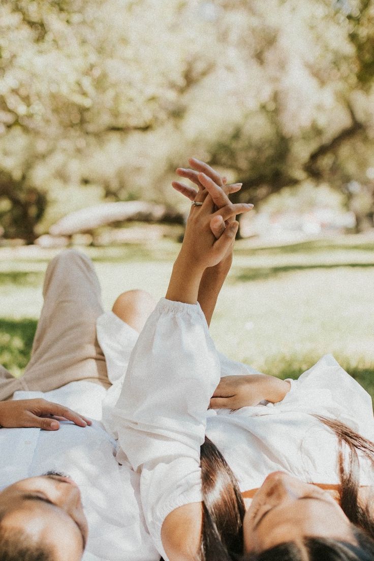 two women laying on the ground with their hands in the air