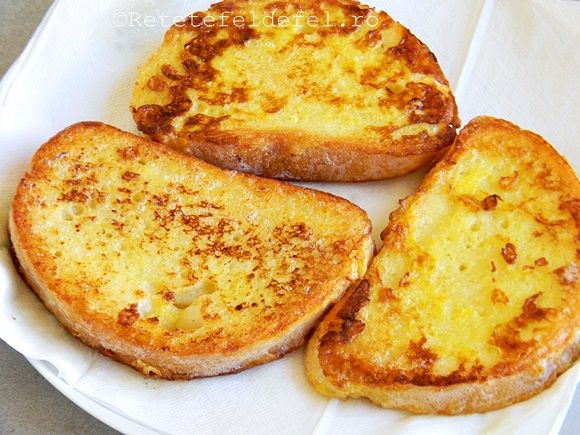 three pieces of bread sitting on top of a white paper plate covered in melted cheese