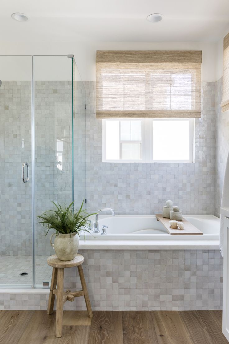 a bathroom with a tub, sink and window