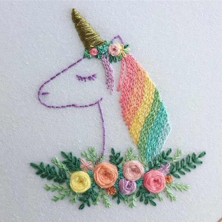 a unicorn with flowers on it's head is embroidered onto a piece of fabric