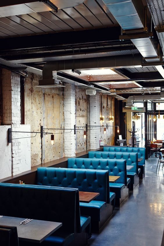 an empty restaurant with blue couches and tables