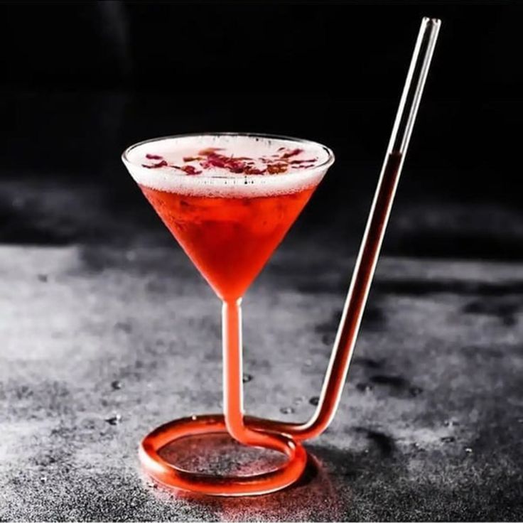 a red drink sitting on top of a table next to a metal straw dispenser