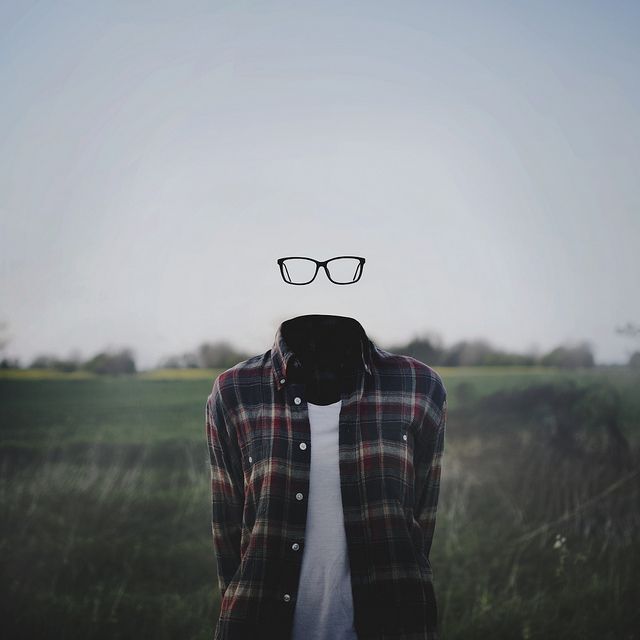 a person wearing glasses standing in a field