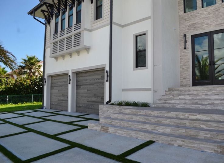 a white house with black shutters and grass