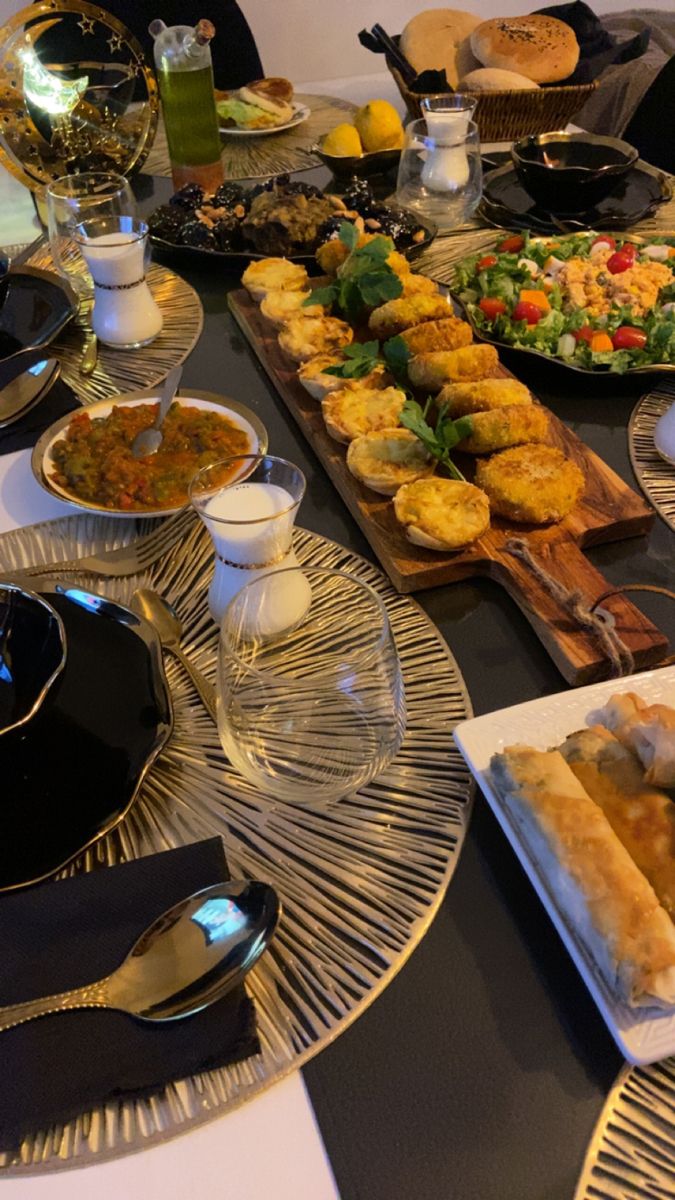 a table full of food with plates and silverware on it, along with other dishes