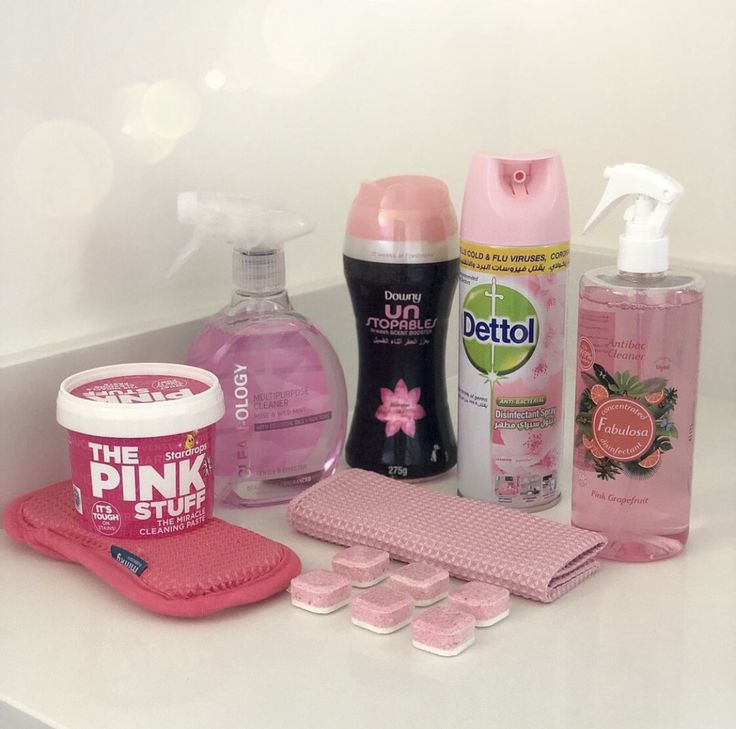 the contents of a bathroom sink with pink stuff and other hygiene products on top of it