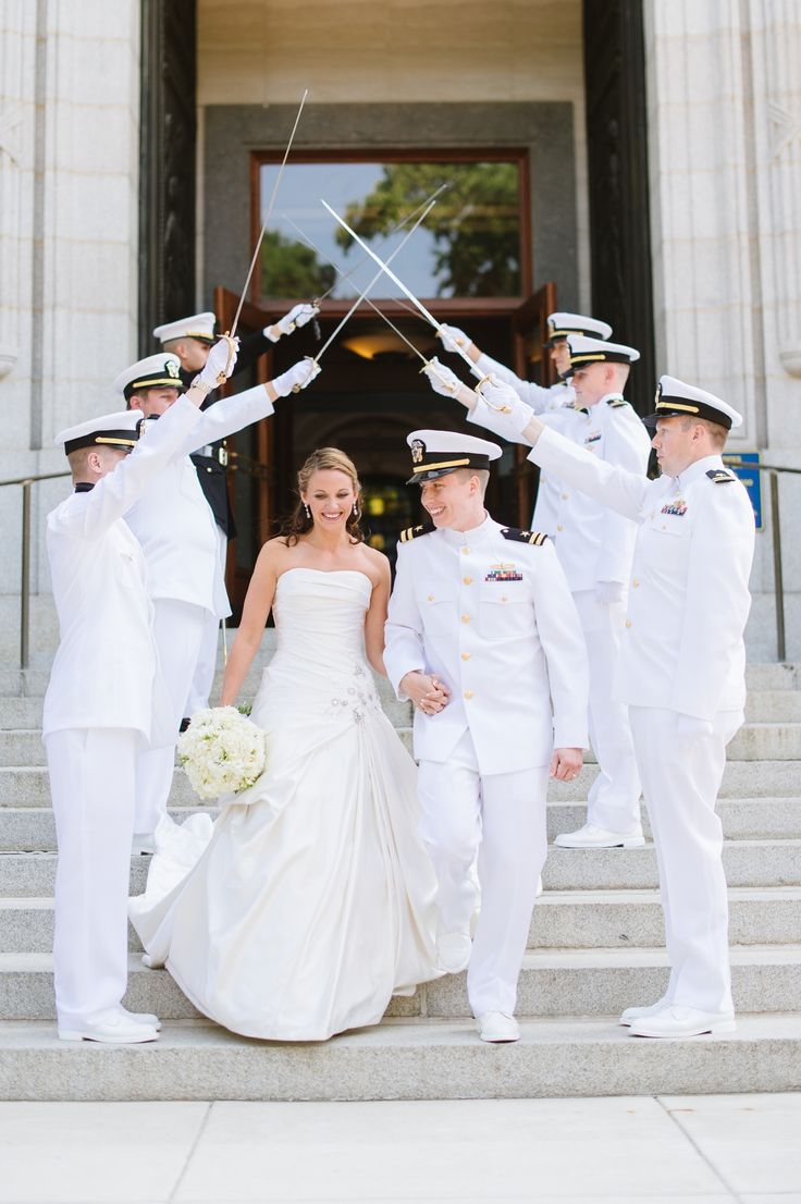 a bride and groom are walking down the steps with their naval officers in uniform behind them