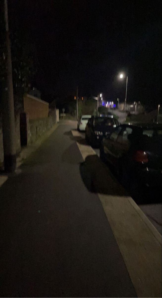 cars parked on the side of a street at night