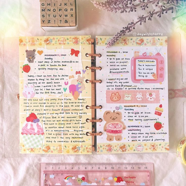 an open planner with teddy bears and other things on it next to a rubber stamp