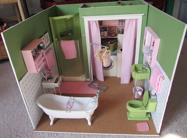 a doll house with a bathtub, sink and toilet in the middle of it