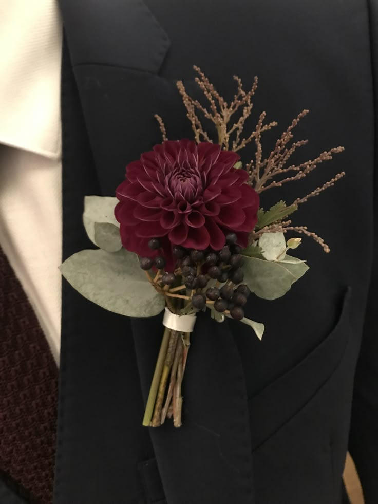 a man wearing a suit and tie with a boutonniere on his lapel