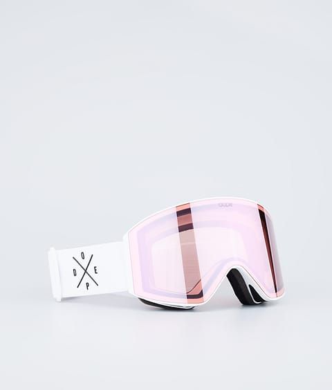 a pair of ski goggles sitting on top of a white surface with pink tinted lenses