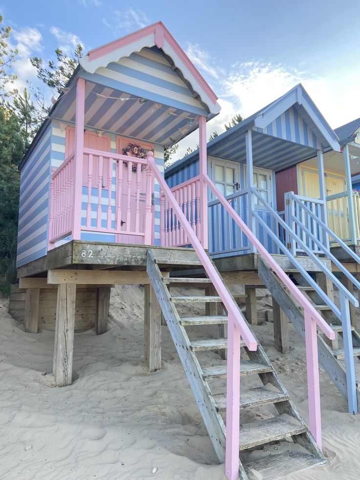 colorful beach huts with stairs leading up to them