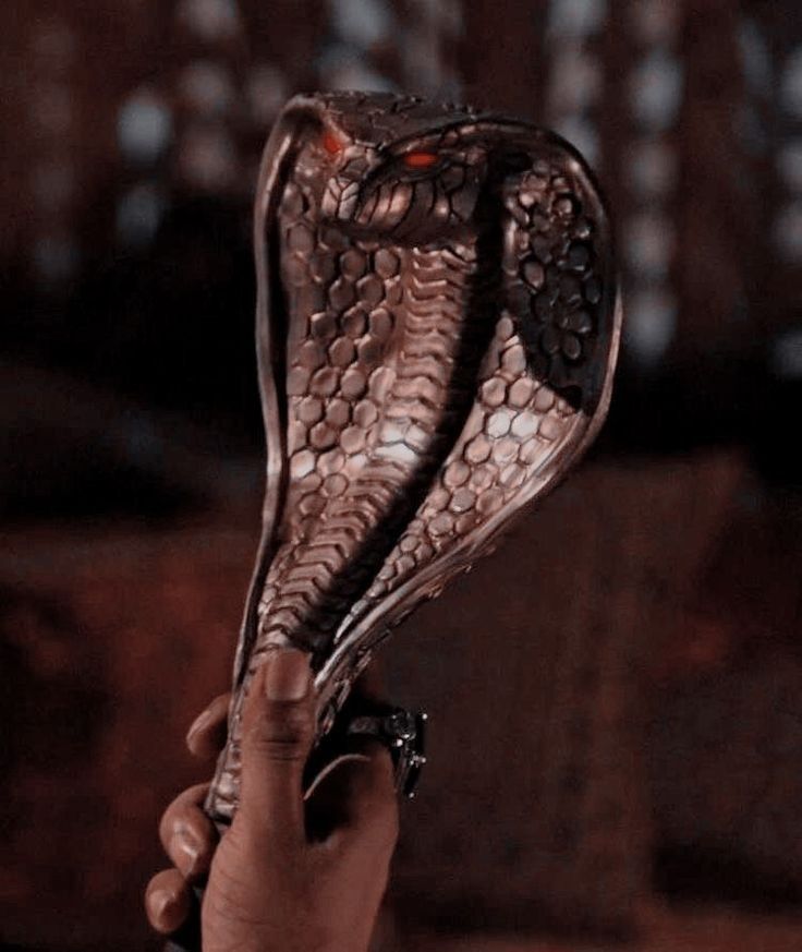 a hand holding an owl shaped object in it's right hand and the other hand