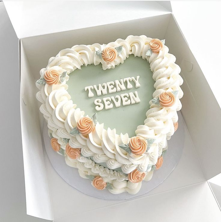 a heart shaped cake with the words twenty seven written on it in white frosting