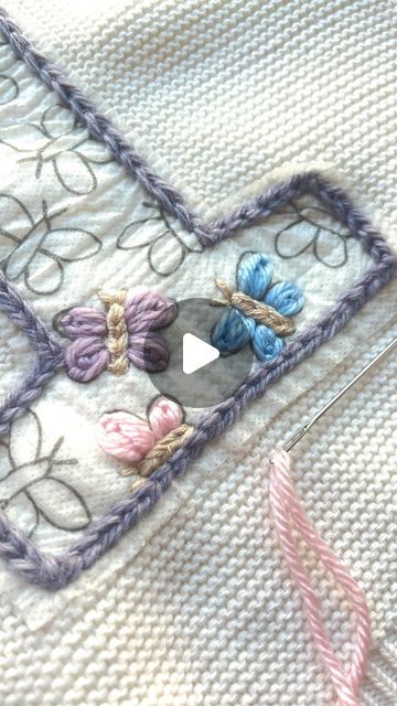 a close up of a piece of cloth with buttons on it and a knitting needle