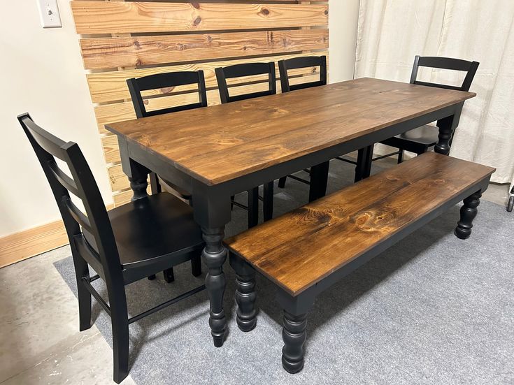 a wooden table with four black chairs around it