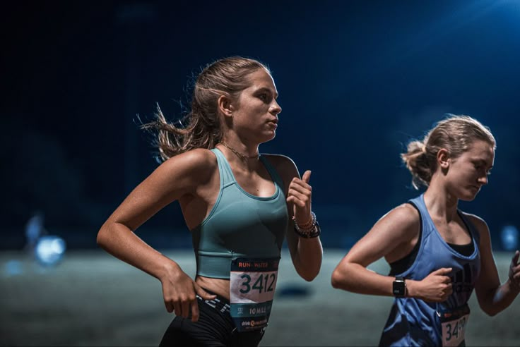 two women running in a race at night