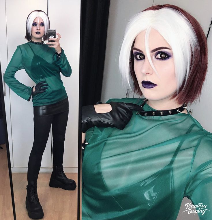 a woman with white hair and black makeup taking a selfie in front of a mirror