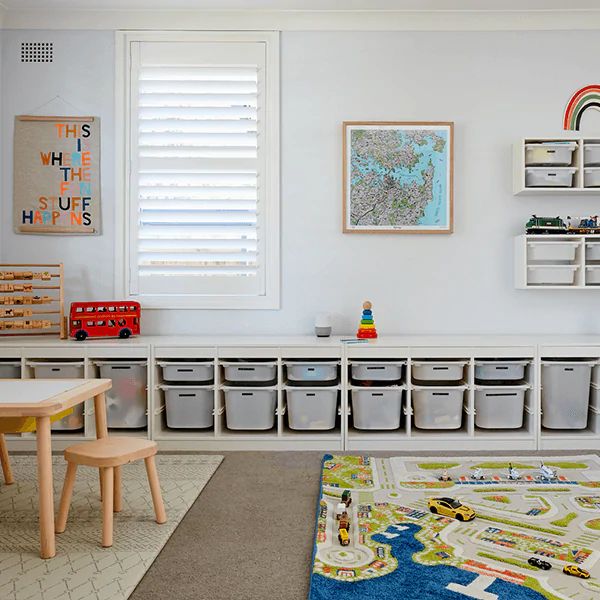 a child's playroom with toy bins and toys