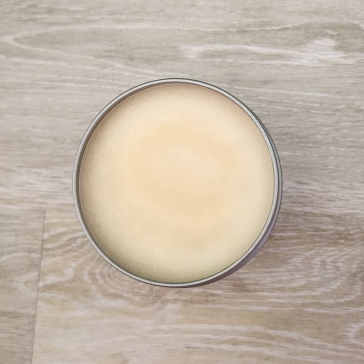 a white cup sitting on top of a wooden table