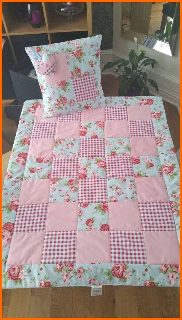 a bed with pink and white checkered bedspread, pillows and pillow cases